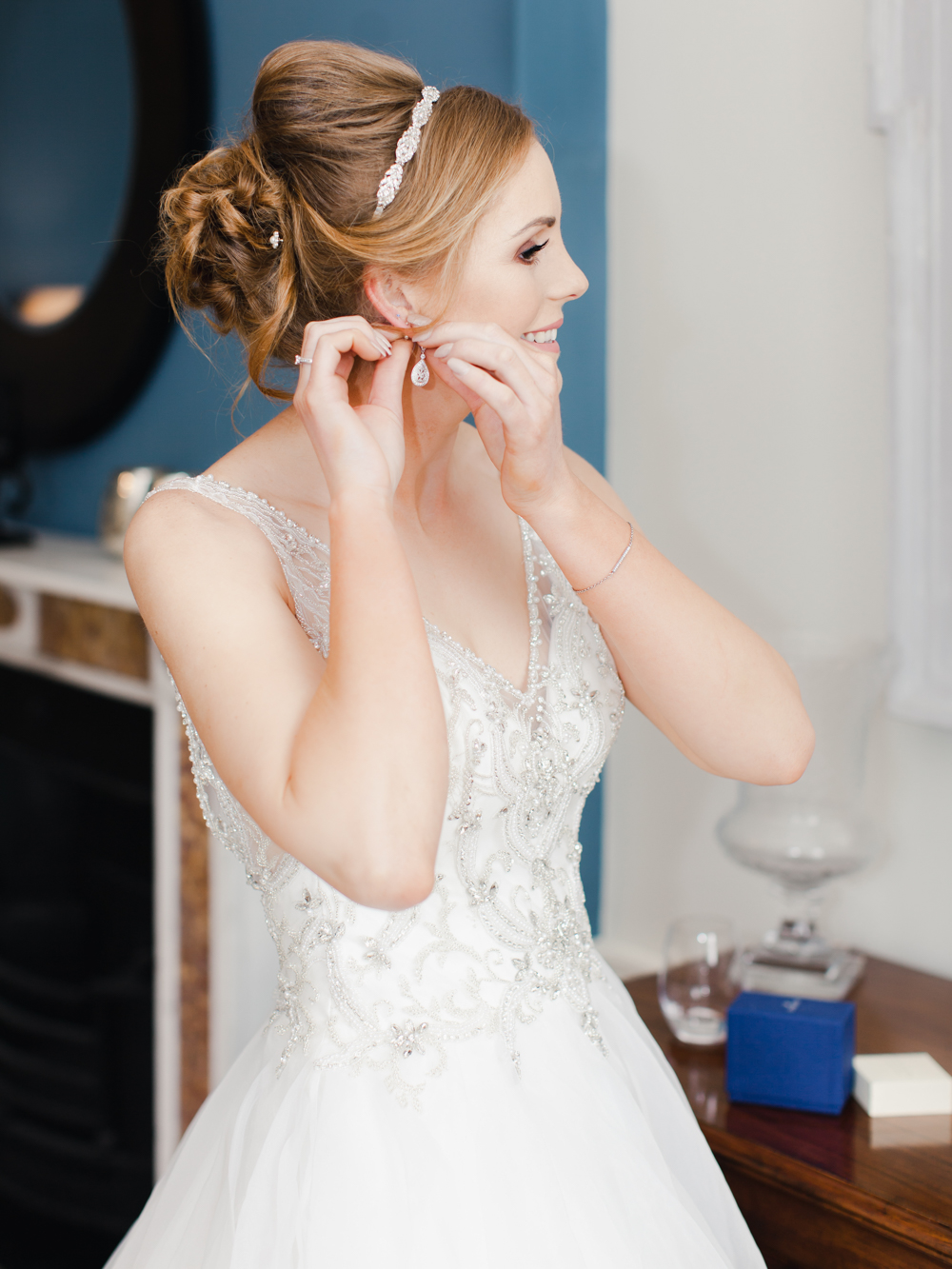 Bride getting ready putting on her earrings at Rockbeare Manor bridal suite