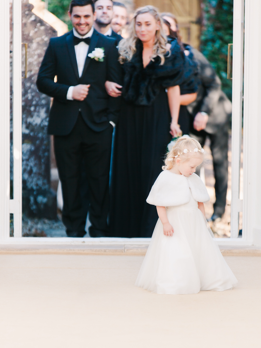 Shy little flower girl makes her way down the ceremony aisle