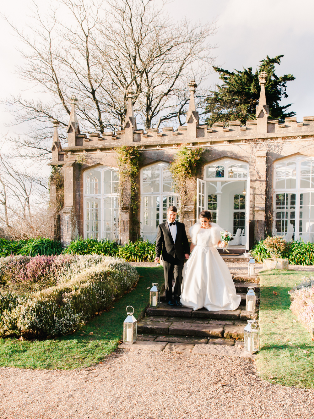 Bride and Groom hold hands in the garden of the country house estate