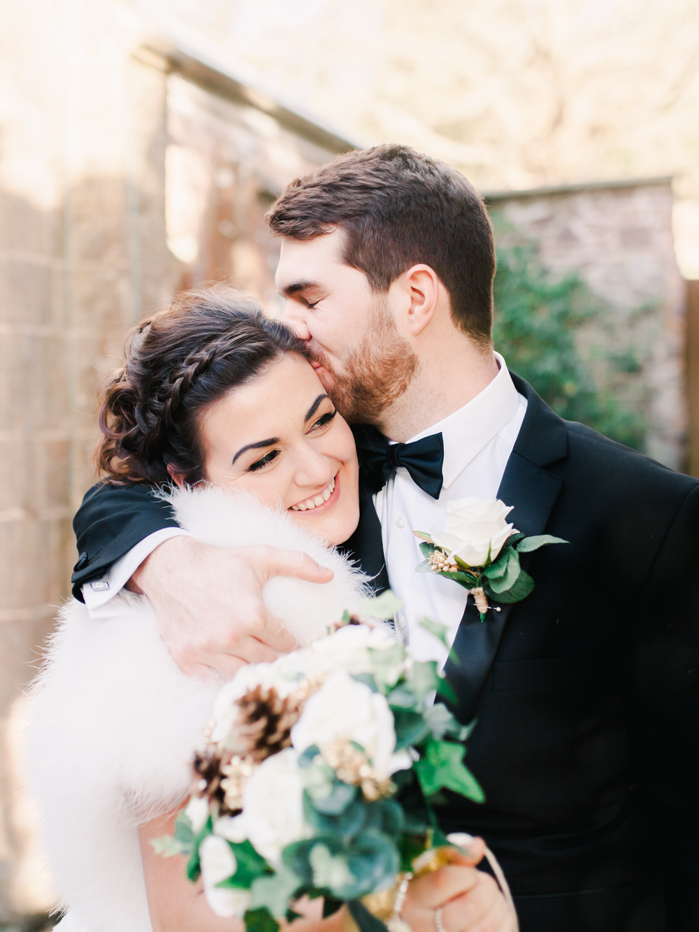 Groom kisses his bride on the forehead after the ceremony at St Audries Park winter wedding