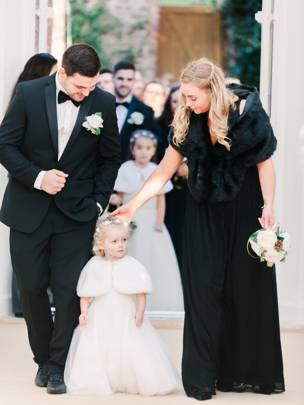 Bridesmaid and flower girl walk down the ceremony aisle