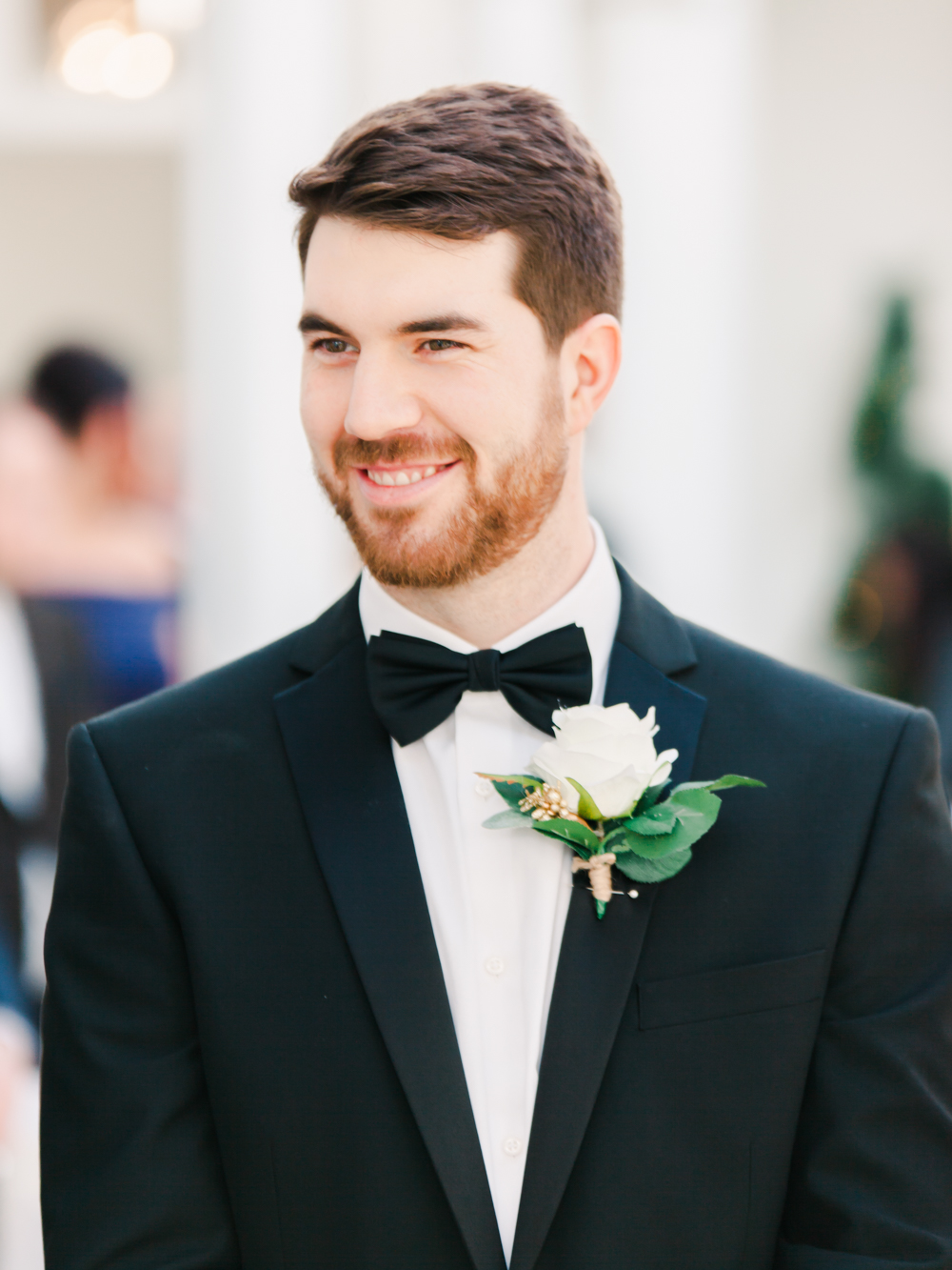 Groom waits for his bride wearing dinner jacket and black bow tie