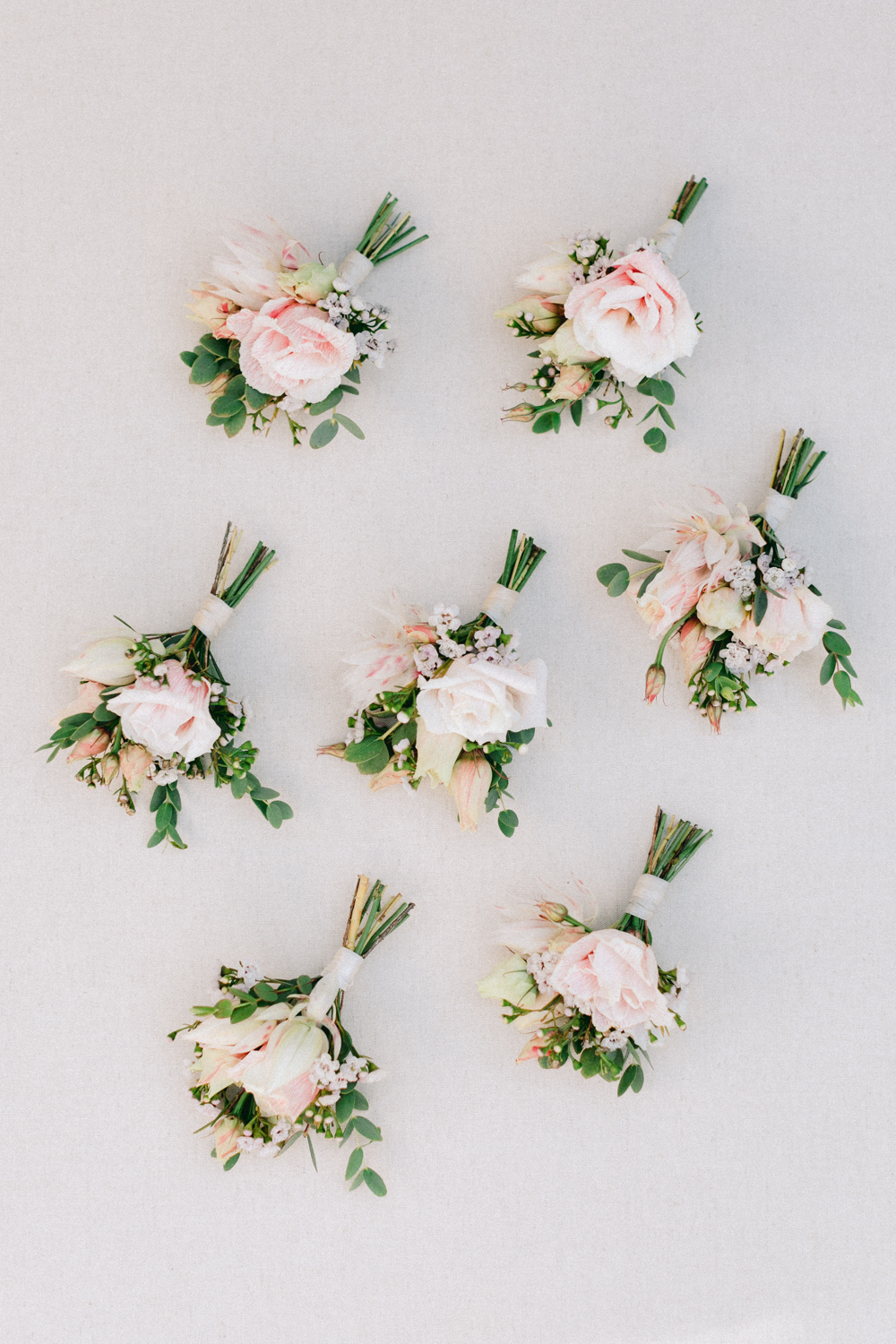 Seven wedding button holes made with pale pink roses