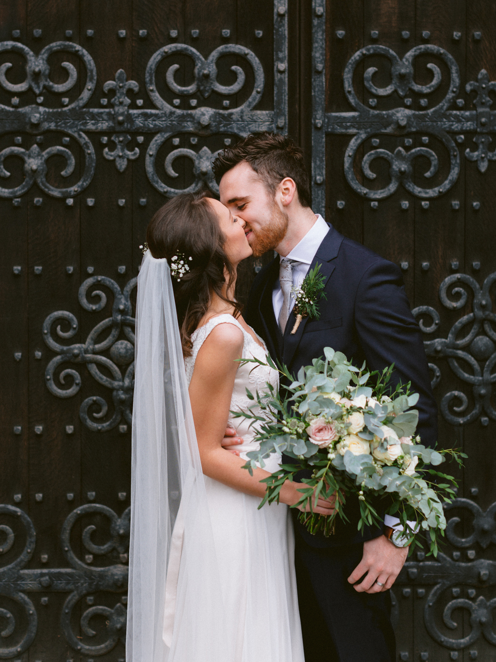 Bride and Groom kiss outside the church at this romantic Cotswolds wedding