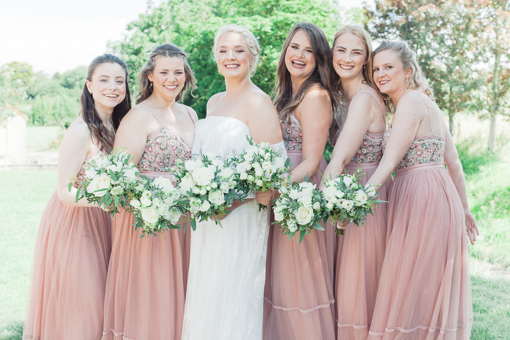 All the bridesmaids at the summer wedding on Rosedew Farm wearing blush gown