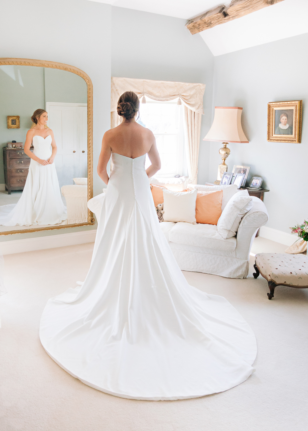 Bride standing in window light in Manor house wedding suite