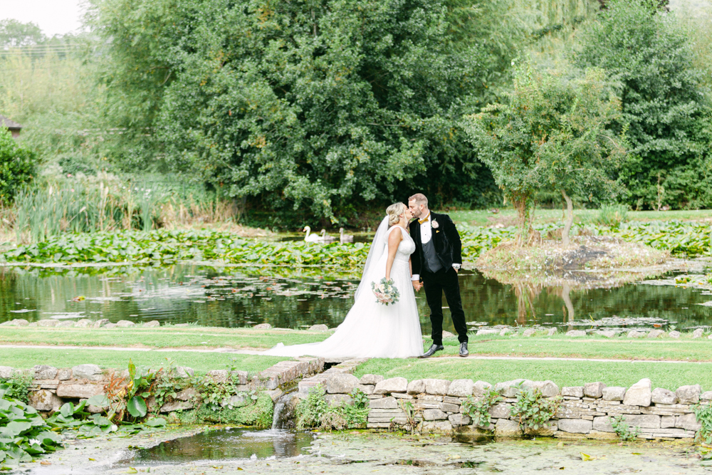 Bride and Groom take romantic stroll at Brinsop Court around the moat
