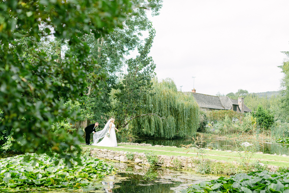 Bride and Groom take romantic stroll at Brinsop Court by the moat