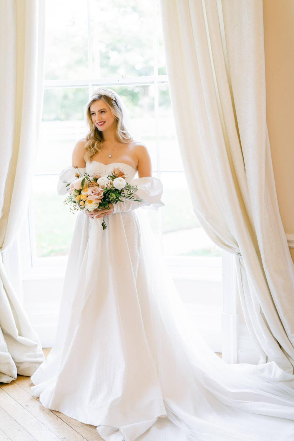 Bride wears luxury wedding gown in window of Eastington Park