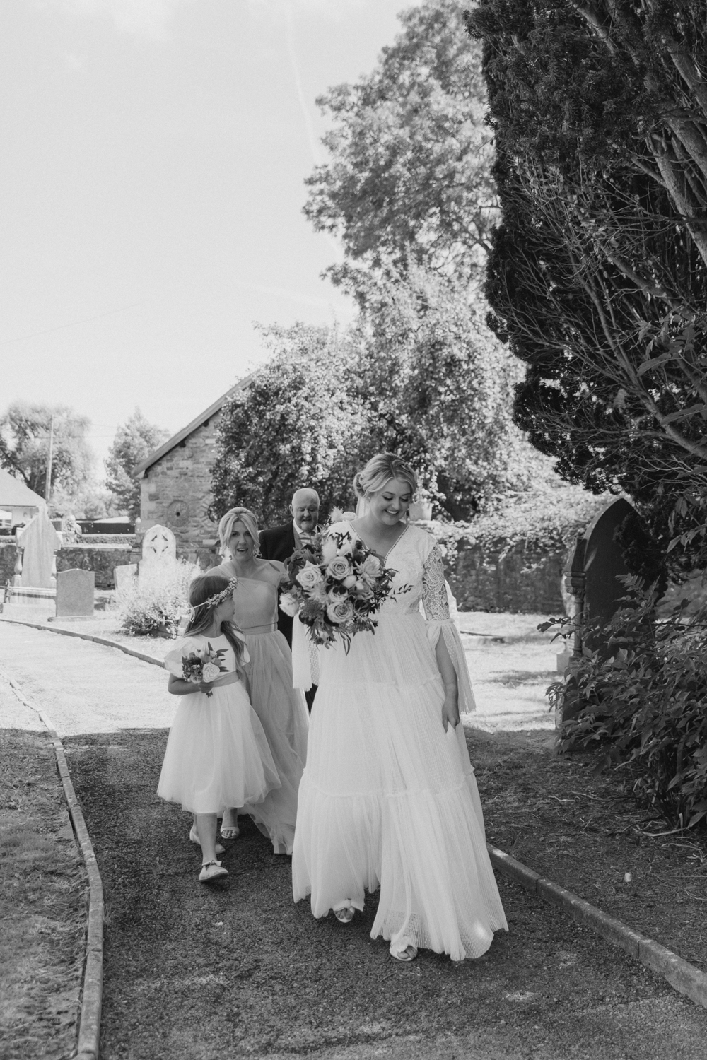Bride and bridesmaids walking outdoors.