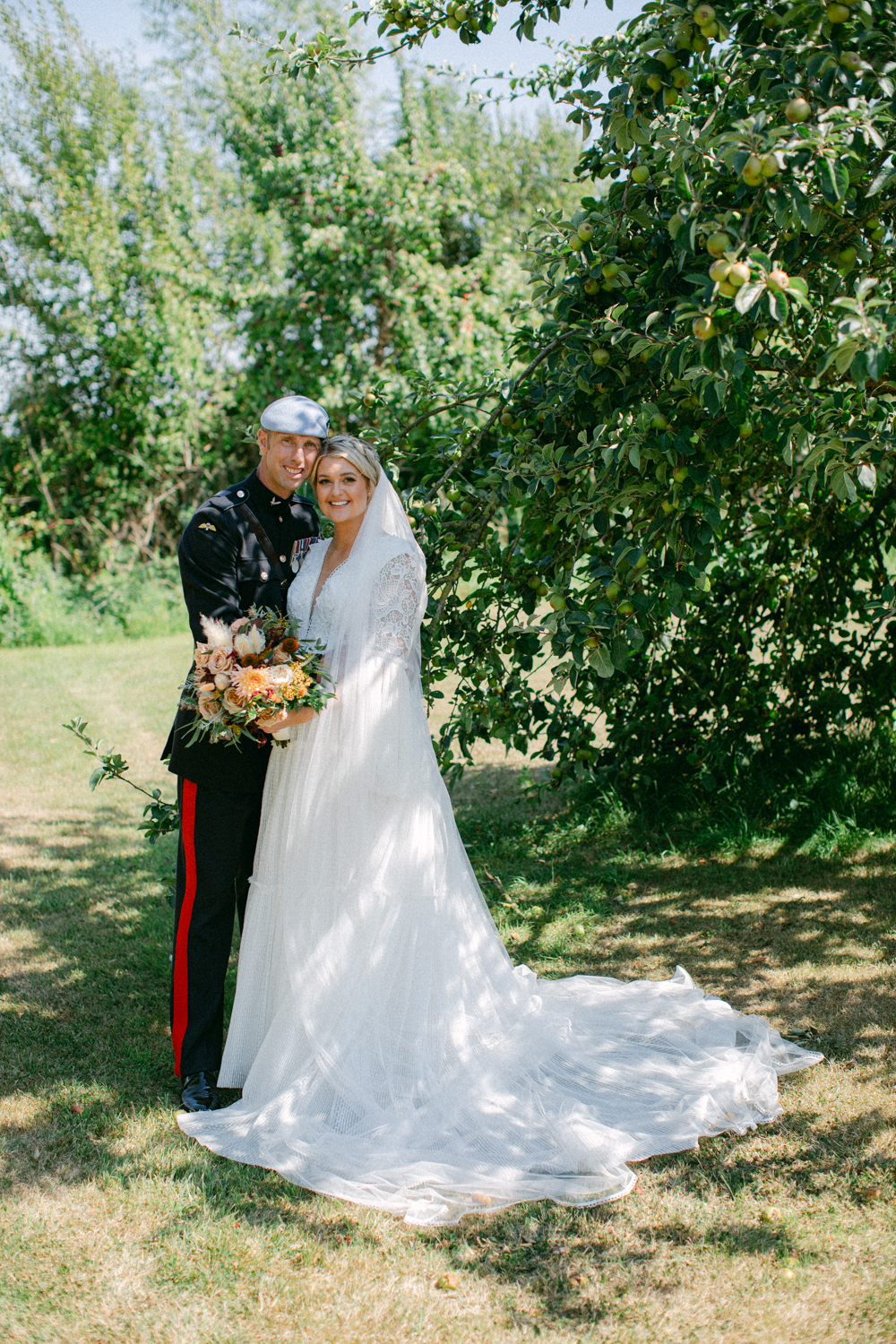 Couple embracing under a tree.