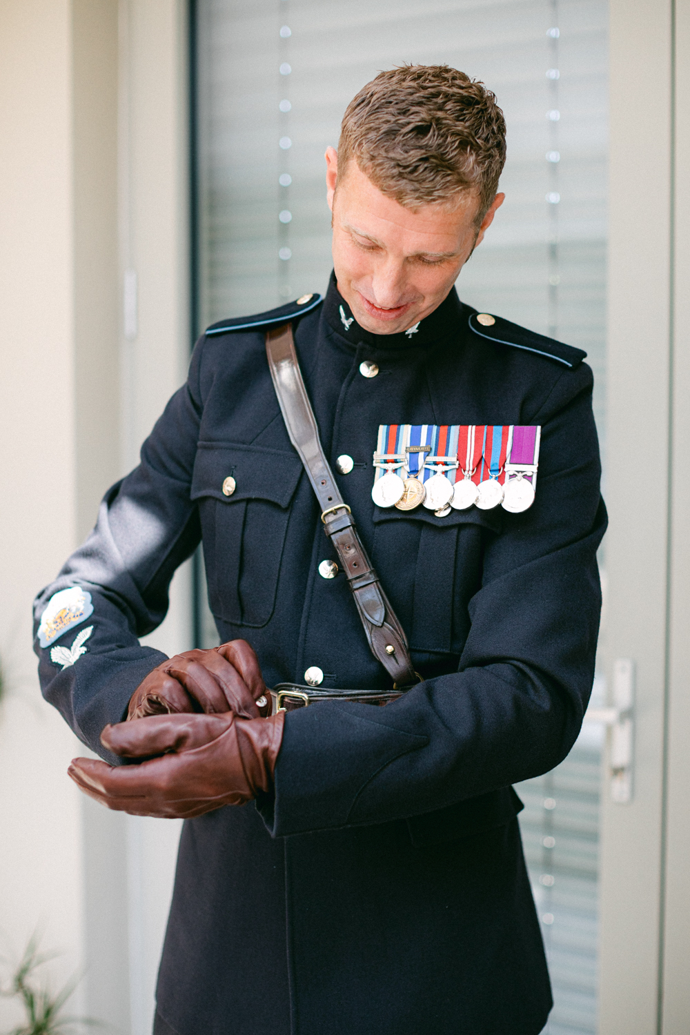 Man in military uniform preparing gloves.