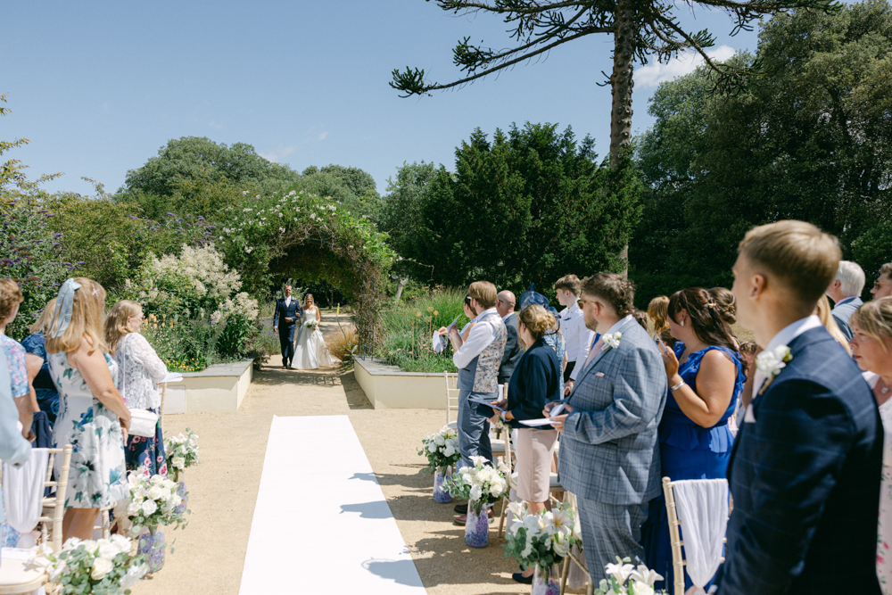 Outdoor wedding at clevedon hall ceremony with guests present.
