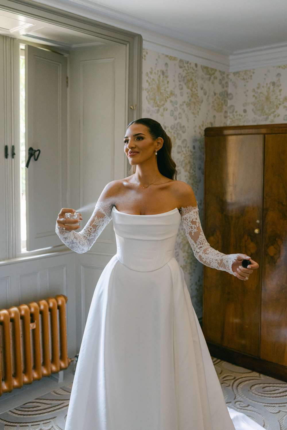 Bride spraying her wedding perfume in the manor house bridal suite